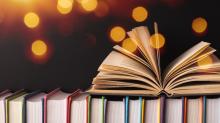 an open book sitting on top of stacked books