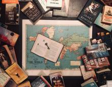 World map in center of page surrounded by books